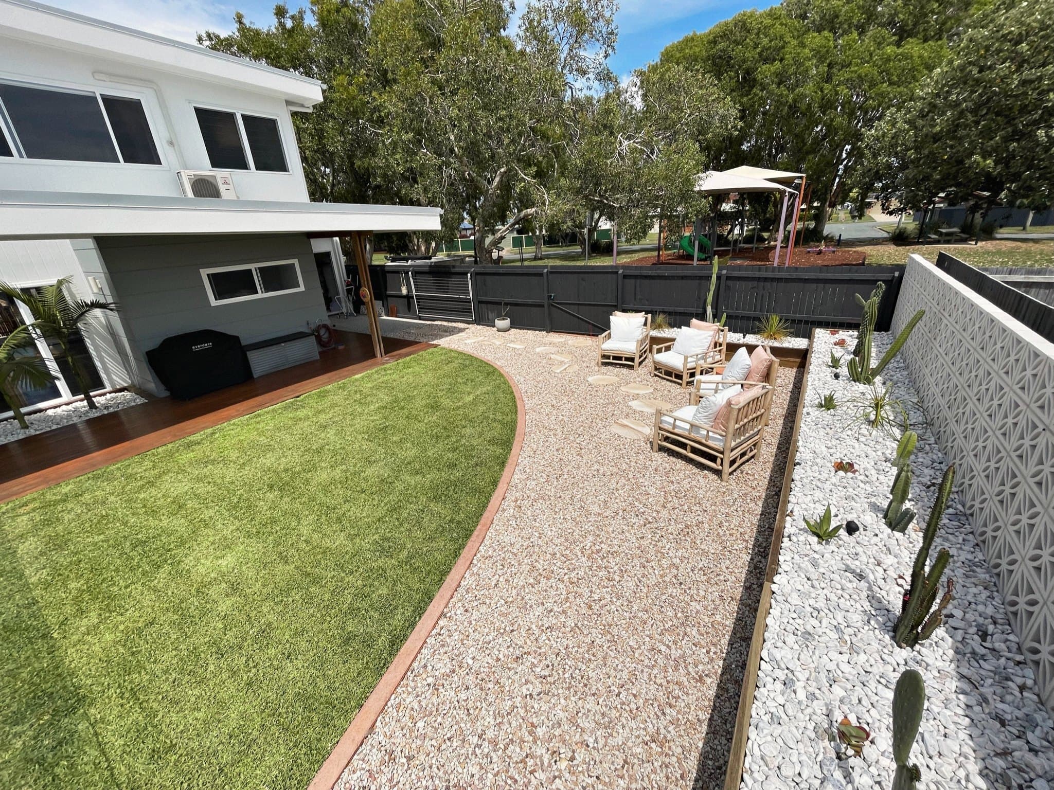 New brick path and white pebble garden beds after a backyard makeover